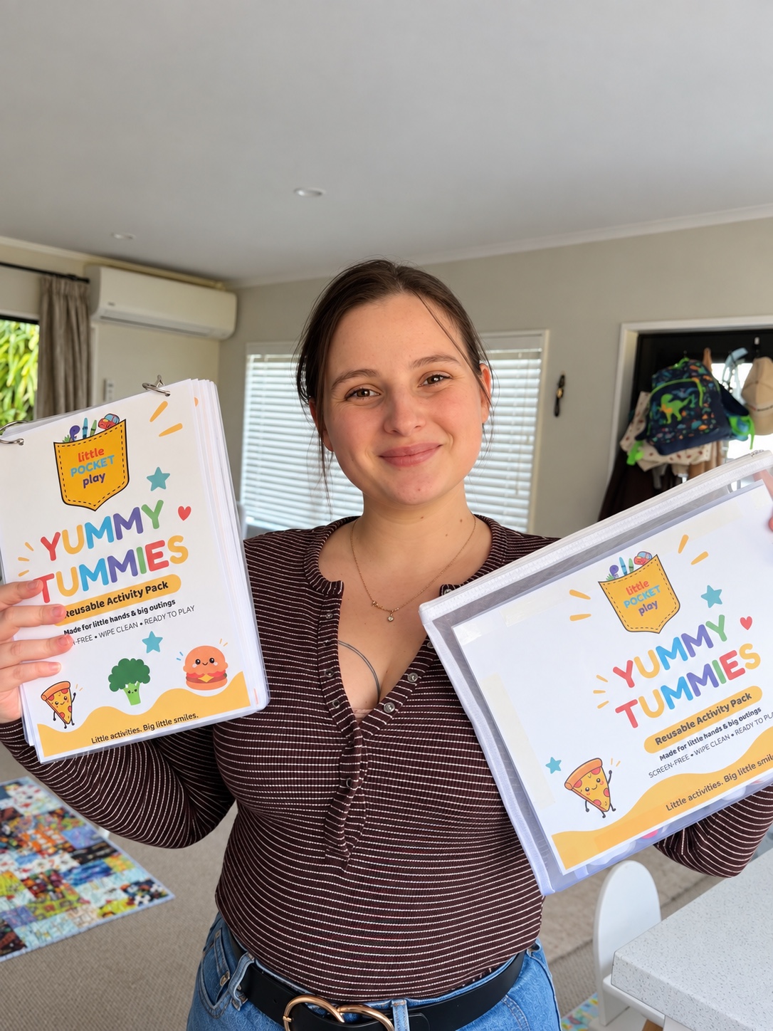 Shiloe holding the Yummy Tummies book and finished pouch at home