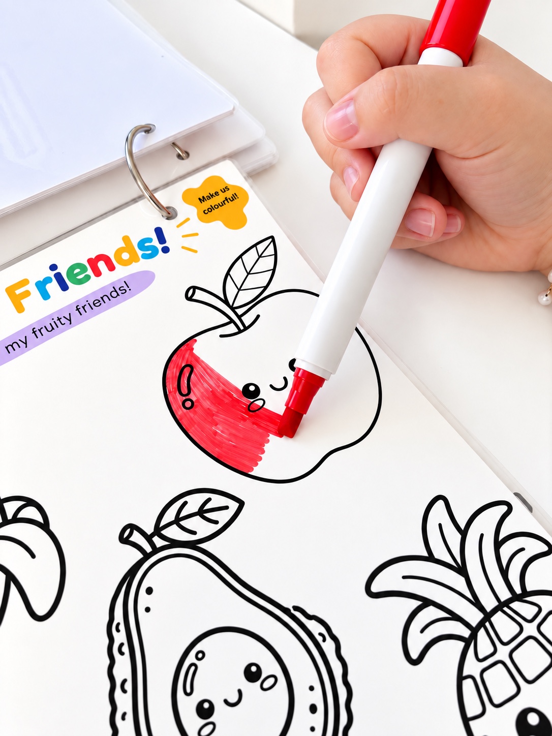 A marker colouring the reusable Fruity Friends apple